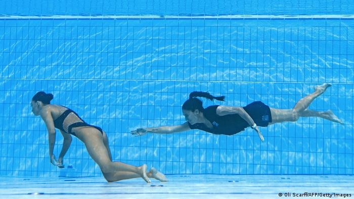 A member of Team USA swims to recover USA's Anita Alvarez from the bottom of the pool at the Budapest 2022 World Aquatics Championships